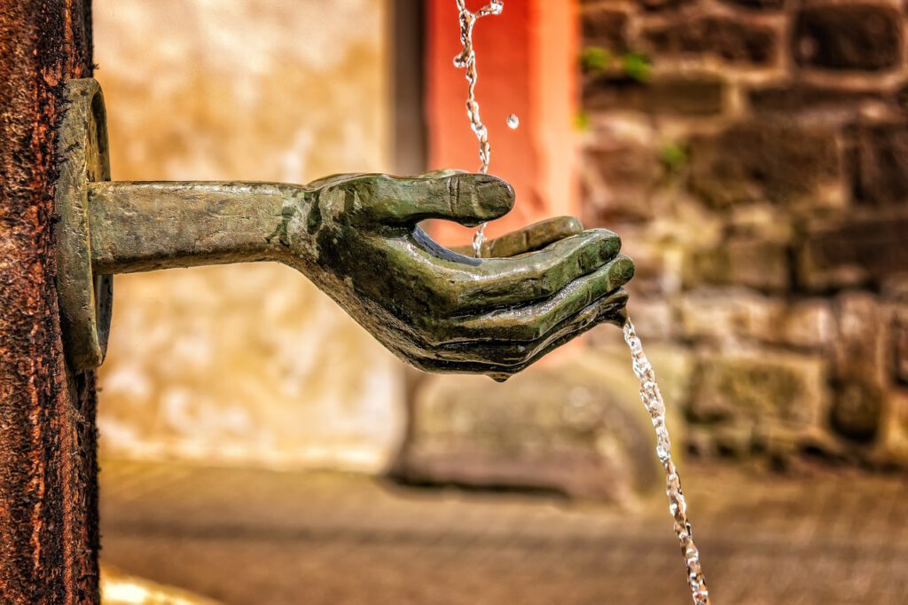 Water pouring into open hands.